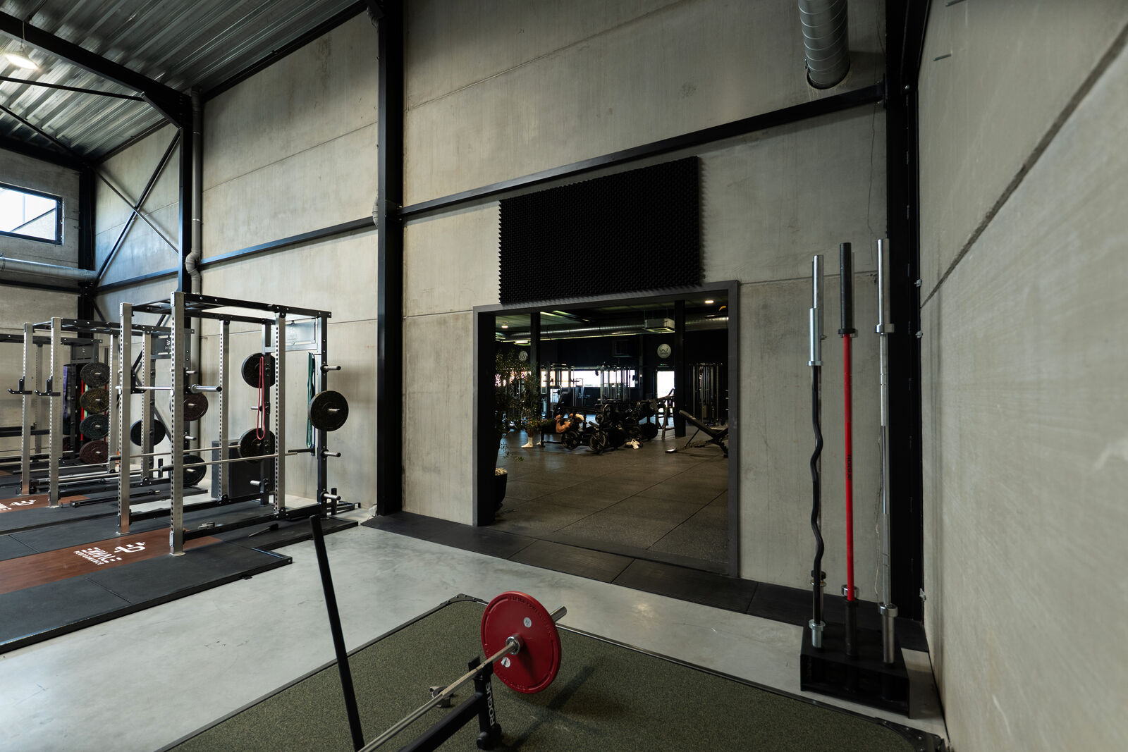 Squat rack met bar langs de wand